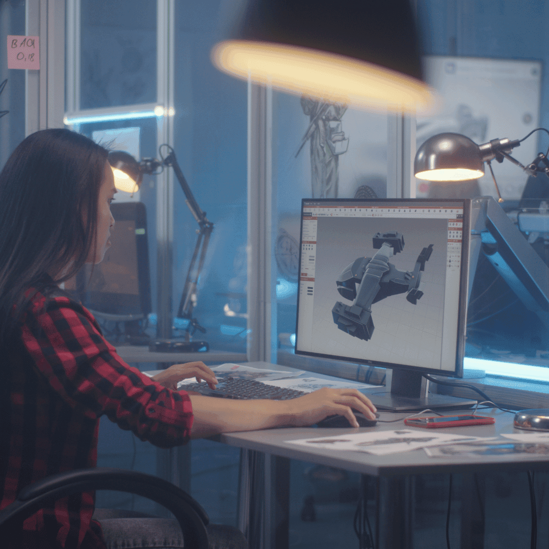 Engineer designing a plastic injection mold using CAD software on a dual-screen setup