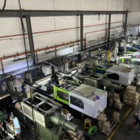 Top view of automated plastic injection molding machines operating on a factory floor