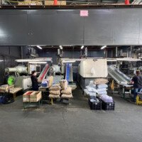 Injection molding production zone with conveyor belts and bagged raw materials